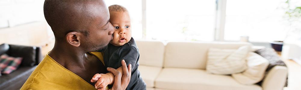 Man holding and kissing his son on the cheek