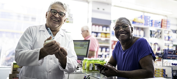 Smiling man and woman at pharmacy counter
